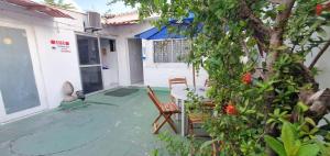 a patio with two chairs and a tree at Casa do Meio Pousada in Recife