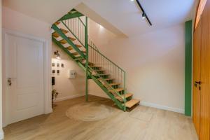 a hallway with a green staircase in a house at Vestal Suites Domo in Cambrils