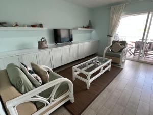 a living room with a couch and a tv at Sunny Villa in the Marina - Excellent Water Views in Jolly Harbour