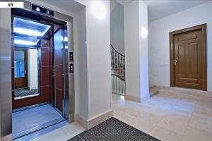 a hallway with a brown door and a staircase at Prague Style Condo 60m2 - 9 Min Walk Wenceslas Sq in Prague