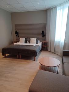 - une chambre avec un lit, une table et un canapé dans l'établissement Moss Hotel & Apartments, à Moss