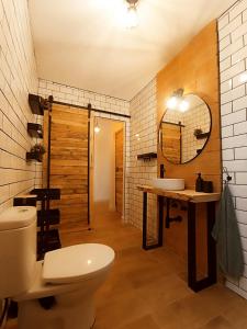 uma casa de banho com um WC, um lavatório e um espelho. em APARTAMENTO AMANECER em Zahara de la Sierra