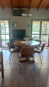 una mesa de comedor y sillas en una habitación con ventanas en Las Guardia en Cortaderas