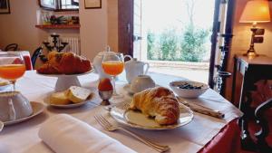 a table with croissants and orange juice and bread at Domus Antiqua Bed & Breakfast in Spello