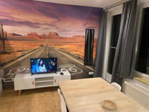 a living room with a painting of a desert road at Mainpark Apartment 4 Schlafzimmer bis zu 10 Personen direkt über AschaffApartment bei Aschaffenburg in Mainaschaff