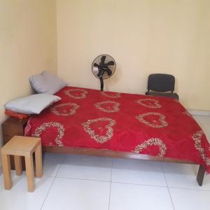 a bedroom with a bed with a red bedspread at ZAC MBAO - Cité enseignants in Kammba