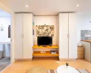 a living room with a tv and white cabinets at Tiny House By Casa Maui in Corralejo