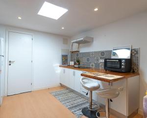 a kitchen with a counter with a microwave and a table at Tiny House By Casa Maui in Corralejo +15 photos