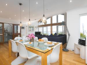 a dining room and living room with a table and chairs at Shamal in Carbis Bay