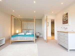 a bedroom with a canopy bed and a bathroom at Shamal in Carbis Bay