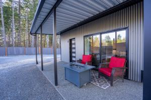 a patio with two red chairs and a table at BC Cabins in Port Alberni