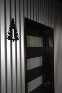 Czarne drzwi z nietoperzem na ścianie w obiekcie BC Cabins w mieście Port Alberni