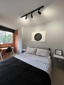 een slaapkamer met een groot bed en een bureau bij Apartamento Moderno Estelar in Sabaneta