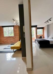 een slaapkamer met een bed en een bank in een kamer bij Apartamento Moderno Estelar in Sabaneta