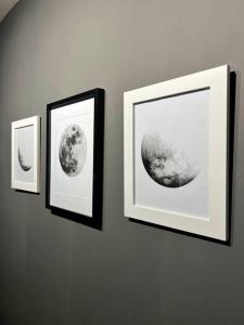 drie ingelijste foto's van de maan aan een muur bij Apartamento Moderno Estelar in Sabaneta