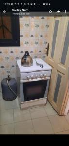 a kitchen with a stove with a tea kettle on it at Al Rayane in Dakar