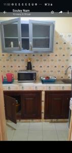 a kitchen with a counter top with a microwave at Al Rayane in Dakar