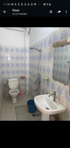 uma casa de banho com um lavatório branco e um WC. em Al Rayane em Dakar