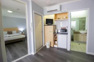 a room with a kitchen and a living room at Caloundra Central Apartment Hotel Official in Caloundra