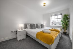 a white bedroom with a large bed and a window at Modern, City Centre -2 Bedroom Apartments in Reading