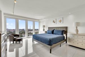 um quarto com uma cama, uma cadeira e janelas em Stunning Bayview! Large condo in beachfront resort with shared pools and jacuzzi em South Padre Island