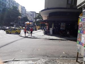 two people are standing on the side of a city street at Quarto no Coração da Tijuca in Rio de Janeiro