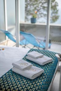 2 serviettes blanches assises au-dessus d'un lit dans l'établissement LE COQ - Splendide vue ! - Beautiful pool - FREE parking !, à Cap d'Ail
