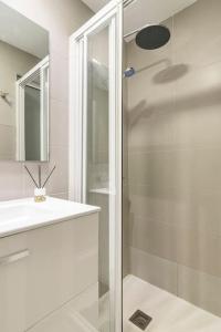 a white bathroom with a shower and a sink at Playa del Pirata IKiGai in San Bartolomé de Tirajana