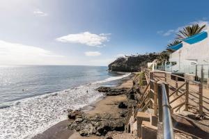 a view of a beach with a building and the ocean at Playa del Pirata IKiGai in San Bartolomé