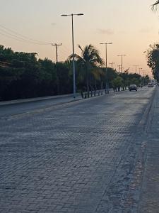 an empty street with cars driving down the road at Sandy's room in Cancún