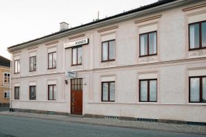 a white building with a red door on a street at Eksjö Stadshotell Annex in Eksjö