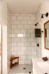 a bathroom with a white tiled shower with a sink at Drift West Coast Getaway in Ucluelet