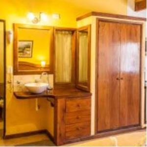 ein Badezimmer mit Waschbecken und Holzschrank in der Unterkunft Tico Tico Apart in Mina Clavero