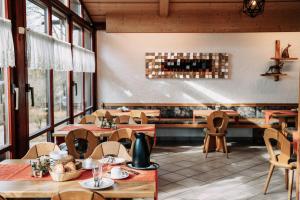 a restaurant with tables and chairs and windows at Waldpension Jägerstüberl in Bad Griesbach