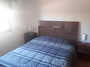 a bedroom with a blue bed and two night stands at Casa en Consistorial in El Tabo