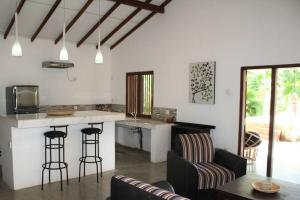 eine Küche und ein Wohnzimmer mit einer Theke und Stühlen in der Unterkunft Casa Tangalle ~ Peaceful, private villa in Tangalle