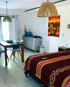 Cet appartement comprend une chambre avec un lit et une table ainsi qu'une cuisine. dans l'établissement La carolina, à Villa Las Rosas