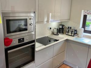 a kitchen with a microwave oven and a sink at The Apartment in Nairn