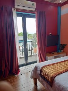 a bedroom with a bed and a large sliding glass door at Bich Ngoan HOTEL in Trà Vinh