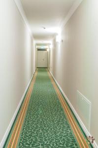 an empty corridor with a green floor and white walls at Pensiunea Terra in Bistriţa