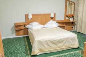 a bedroom with a large bed with white pillows at Pensiunea Terra in Bistriţa