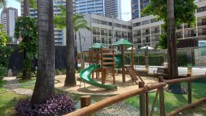 a playground with a slide in a park with trees at Maravilhoso Apartamento na Beira Mar in Fortaleza
