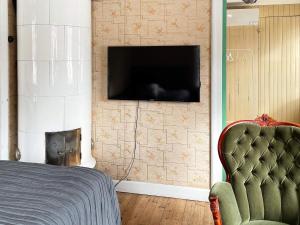 ein Schlafzimmer mit einem TV an der Wand mit einem Stuhl in der Unterkunft Holiday home FORSHEDA II in Forsheda