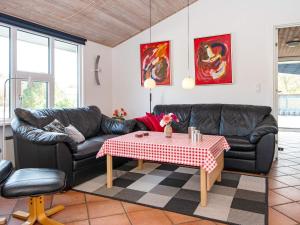 Nørbyにある8 person holiday home in Ringk bingのリビングルーム(黒い革張りのソファ、テーブル付)