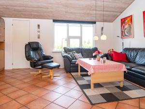 a living room with black leather furniture and a table at 8 person holiday home in Ringk bing in Nørby