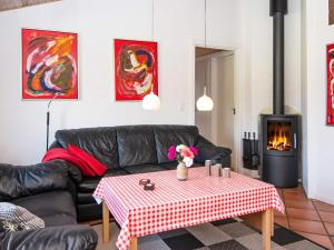 a living room with a black leather couch and a table at 8 person holiday home in Ringk bing in Nørby