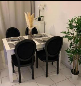 une table avec quatre chaises et une table avec des plaques dans l'établissement Appartement Premium Le Marquis, à Pfastatt
