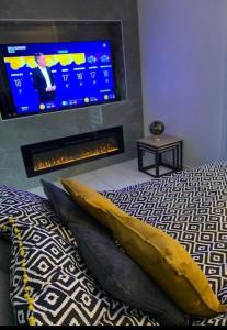 - une chambre avec un lit et une télévision murale dans l'établissement Appartement Premium Le Marquis, à Pfastatt