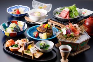 a table with plates of food and bowls of food at Rurikoh in Kaga