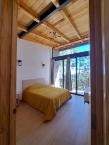 una camera con un letto e una grande finestra di Cabaña La Finca Mazamitla a Mazamitla